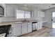 Bright kitchen featuring white cabinets, stainless steel dishwasher, and sliding glass door to the backyard at 8877 Perfect Diamond Ct, Las Vegas, NV 89129