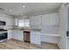 Open concept kitchen with white cabinetry, stainless appliances, and light-colored wood-look floors at 8877 Perfect Diamond Ct, Las Vegas, NV 89129