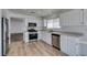 This kitchen features white cabinets, stainless appliances, and light colored wood-look flooring at 8877 Perfect Diamond Ct, Las Vegas, NV 89129