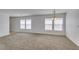 Spacious living room featuring neutral carpet and multiple windows for ample natural light at 8877 Perfect Diamond Ct, Las Vegas, NV 89129