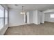 Open-concept living room featuring neutral carpet and view of the kitchen with stainless steel fridge at 8877 Perfect Diamond Ct, Las Vegas, NV 89129