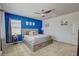 Comfortable bedroom featuring a ceiling fan, natural light from a window, and a blue accent wall at 8898 Sasquatch Run Ave, Las Vegas, NV 89166