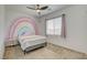 Cute bedroom with a rainbow painted on the wall, a ceiling fan, and natural light from the window at 8898 Sasquatch Run Ave, Las Vegas, NV 89166