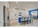 Well-lit kitchen with stainless steel appliances, island seating, and a view into the dining area at 8898 Sasquatch Run Ave, Las Vegas, NV 89166