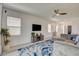 Spacious living area with a ceiling fan, large windows, and an entertainment center at 8898 Sasquatch Run Ave, Las Vegas, NV 89166