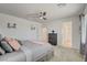 Bright main bedroom featuring a ceiling fan, a large bed, and an ensuite bathroom at 8898 Sasquatch Run Ave, Las Vegas, NV 89166