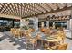 Inviting outdoor patio with a fireplace, a wooden pergola, and ample seating under the shaded structure at 8898 Sasquatch Run Ave, Las Vegas, NV 89166