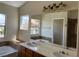 Bright bathroom featuring dual sinks, a soaking tub, and a large mirror with vanity lighting at 9004 Dulcimer Ln, Las Vegas, NV 89123
