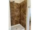 Close-up of a walk-in shower with floor-to-ceiling marbled tile and modern shower head at 9004 Dulcimer Ln, Las Vegas, NV 89123