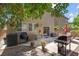 Outdoor patio area with barbeque and seating under mature trees, provides a relaxing space to grill and dine at 9218 Grassy Weep Ct, Las Vegas, NV 89178