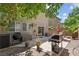 Outdoor patio area with barbeque and seating under mature trees, provides a relaxing space to grill and dine at 9218 Grassy Weep Ct, Las Vegas, NV 89178