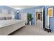 Primary bedroom featuring blue walls, carpet and a white paneled bed at 9218 Grassy Weep Ct, Las Vegas, NV 89178