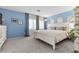 Primary bedroom featuring blue walls, carpet and a white paneled bed at 9218 Grassy Weep Ct, Las Vegas, NV 89178