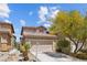 Daytime view of a two-story home featuring a two-car garage, landscaped front yard, and a welcoming facade at 9218 Grassy Weep Ct, Las Vegas, NV 89178