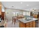 Bright kitchen features tile flooring and an island with stainless steel sink at 9218 Grassy Weep Ct, Las Vegas, NV 89178