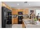 Kitchen with granite countertops, stainless steel sink, black appliances and wooden cabinets at 9218 Grassy Weep Ct, Las Vegas, NV 89178