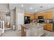 Open kitchen with wooden cabinets, tile floors, black appliances and kitchen island with sink at 9218 Grassy Weep Ct, Las Vegas, NV 89178