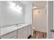 Well-lit bathroom with white vanity, modern fixtures, and stylish wood-look flooring at 9325 W Desert Inn Rd # 120, Las Vegas, NV 89117