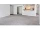 Spacious living area with neutral carpet flooring and a partial view of the updated kitchen at 9325 W Desert Inn Rd # 120, Las Vegas, NV 89117