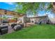 Backyard patio area with new outdoor furniture, lush lawn, and a shaded pergola, perfect for entertaining at 942 Westminster Ave, Las Vegas, NV 89119