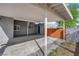 Covered carport area featuring an entry door, wood privacy fence, and concrete flooring at 942 Westminster Ave, Las Vegas, NV 89119