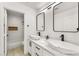 Bathroom featuring dual sinks, modern hardware, and an adjacent tub with shower at 9795 La Cienega St, Las Vegas, NV 89183