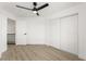 Bright bedroom features light wood floors, ceiling fan, closet with sliding doors, and white trim at 9795 La Cienega St, Las Vegas, NV 89183