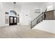 Grand entryway featuring high ceilings, a modern chandelier, and a staircase with black railings at 9795 La Cienega St, Las Vegas, NV 89183