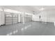 Spacious three-car garage with gray epoxy floors and paneled doors, suitable for vehicles or storage at 9795 La Cienega St, Las Vegas, NV 89183