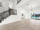 Open-concept living room with a modern chandelier, staircase, and sliding glass doors to the pool area at 9795 La Cienega St, Las Vegas, NV 89183