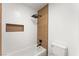 Bathroom shower features a tiled wall, matte black fixtures, and a built-in shelf at 9795 La Cienega St, Las Vegas, NV 89183