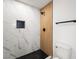 Walk-in shower featuring marble walls, modern fixtures, and black hexagonal tile floors at 9795 La Cienega St, Las Vegas, NV 89183