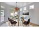 Bright dining room with modern light fixture, glass table, and white walls at 10405 Junction Hill Dr, Las Vegas, NV 89134