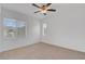 An empty bedroom space illuminated by a ceiling fan and natural light from the windows at 10410 Poplar Park Ave, Las Vegas, NV 89166