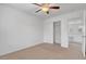 A spacious bedroom with neutral walls and carpeting, with a ceiling fan and natural light at 10410 Poplar Park Ave, Las Vegas, NV 89166