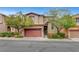 Charming two-story home features a terracotta-colored garage door, lovely landscaping, and inviting curb appeal at 10410 Poplar Park Ave, Las Vegas, NV 89166