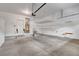 A clean and spacious garage featuring overhead storage, ample lighting, and white walls at 10410 Poplar Park Ave, Las Vegas, NV 89166