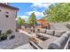 A beautiful outdoor living space with a paver patio, stylish seating, hot tub, and lush landscaping at 10432 Britton Hill Ave, Las Vegas, NV 89129