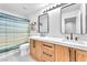 Modern bathroom with double vanity, sleek mirrors, and a stylish shower curtain at 10432 Britton Hill Ave, Las Vegas, NV 89129