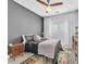 Bedroom featuring a large window, neutral tones, stylish furnishings, and ceiling fan at 10432 Britton Hill Ave, Las Vegas, NV 89129
