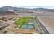 Aerial view of a community park with tennis courts, green spaces, and desert surroundings at 10432 Britton Hill Ave, Las Vegas, NV 89129