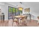 Bright dining room with wood table, chairs, modern light fixture, and view to the outdoor patio at 10432 Britton Hill Ave, Las Vegas, NV 89129