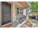 Close-up of the front porch featuring a cozy sitting area, potted plants, and a welcoming entrance at 10432 Britton Hill Ave, Las Vegas, NV 89129