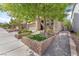 Charming home with well-designed front yard landscaping, including brick-lined planters and healthy trees at 10432 Britton Hill Ave, Las Vegas, NV 89129