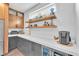 Bright kitchen featuring floating shelves, custom cabinets, white countertops, and stainless steel appliances at 10432 Britton Hill Ave, Las Vegas, NV 89129