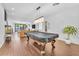 Open floor plan living room with a pool table, hardwood floors, modern lighting, and backyard access at 10432 Britton Hill Ave, Las Vegas, NV 89129