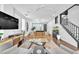Open-concept living room with comfortable seating, wood floors, and staircase at 10432 Britton Hill Ave, Las Vegas, NV 89129