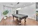 Bright living room featuring a covered billiards table, wood floors, and contemporary lighting at 10432 Britton Hill Ave, Las Vegas, NV 89129