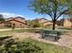 Community green space with picnic tables, a shade tree, and neighborhood homes in the background at 1139 Via Partito, Henderson, NV 89052