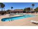 Resort-style swimming pool with multiple lounge chairs, shade structures, and a nearby building in a community setting at 1139 Via Partito, Henderson, NV 89052